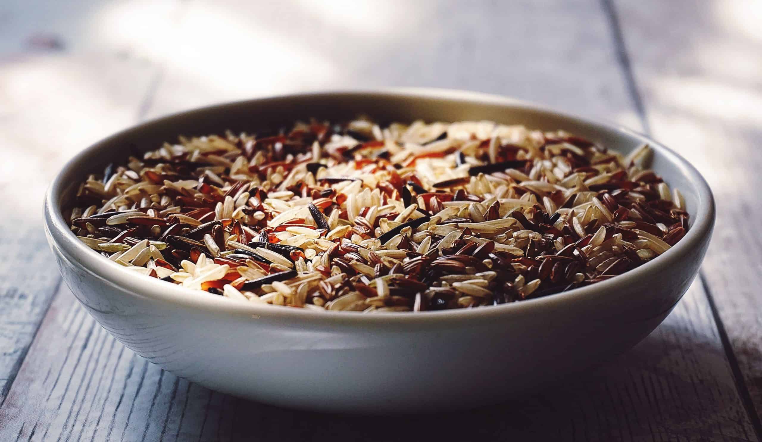 A ceramic bowl containing brown rice.