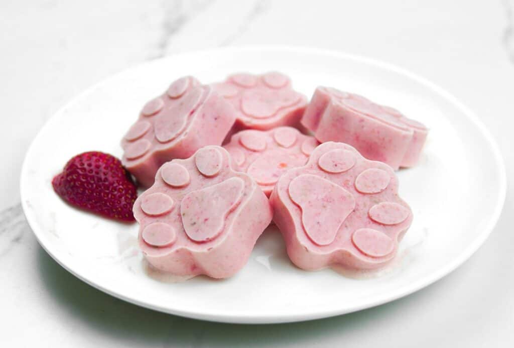 Pink dog ice cream in the shape of paws.
