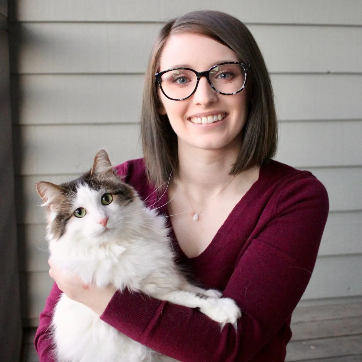 Photo of veterinarian Nicole Wanner holding a cat on her arms. Nicole is part of the Pawleaks veterinary team.